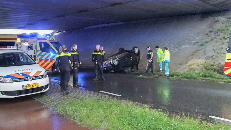 Gloednieuwe auto over de kop bij viaduct over Middenweg in Heerhugowaard