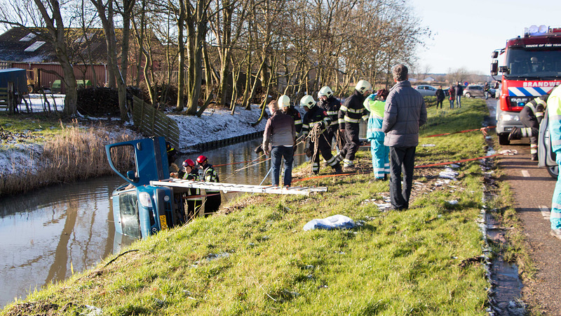 Auto met twee inzittenden te water langs Nauertogt