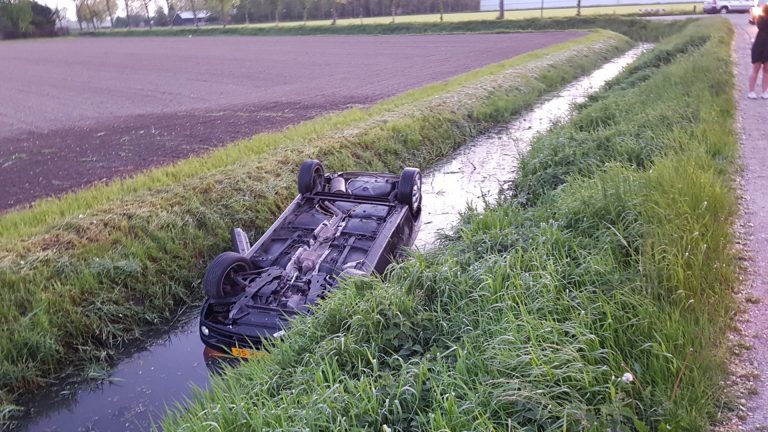 Auto op de kop in sloot, omstanders redden bestuurder