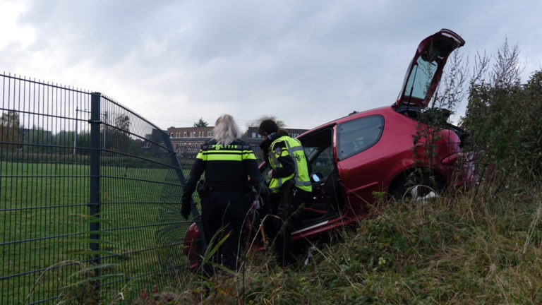 Auto schiet van de rotonde Schinkelwaard en ramt hek