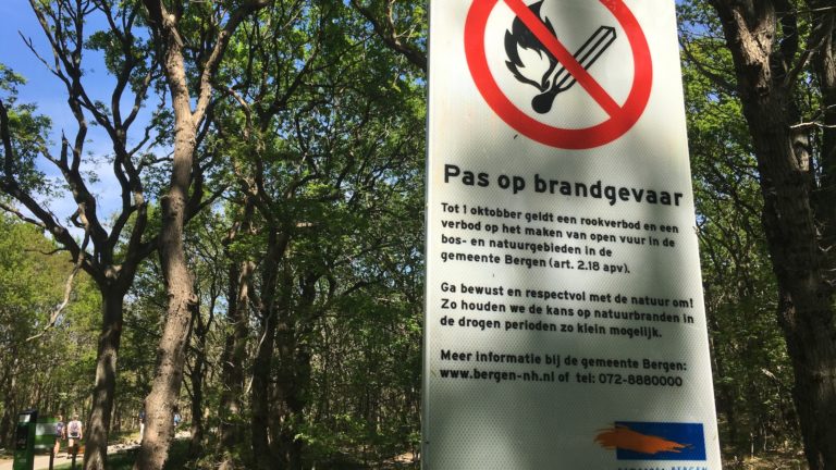 Resten van kampvuur in gortdroog duingebied nabij Nieuweweg in Groet