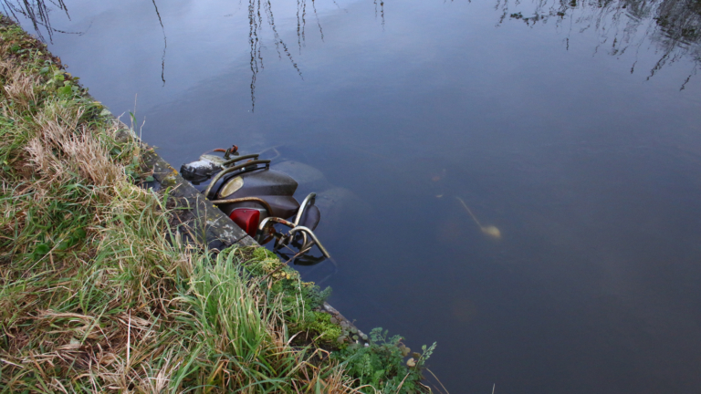 Politie en handhavers vissen gestolen scooter uit sloot langs Middenweg