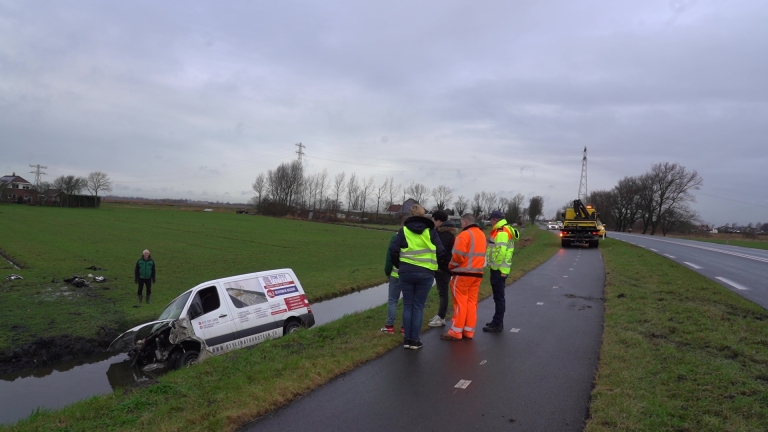 Bus na mogelijke slip in sloot, bestuurder ongedeerd