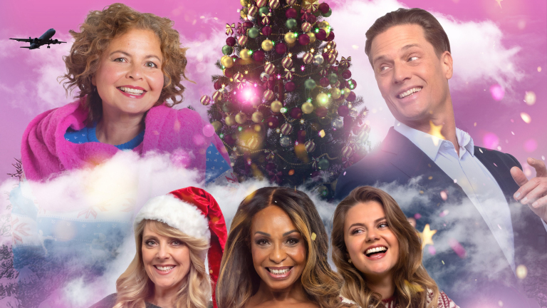 Vijf lachende mensen voor een versierde kerstboom en roze lucht met wolken; een vliegtuig vliegt bovenin de lucht.