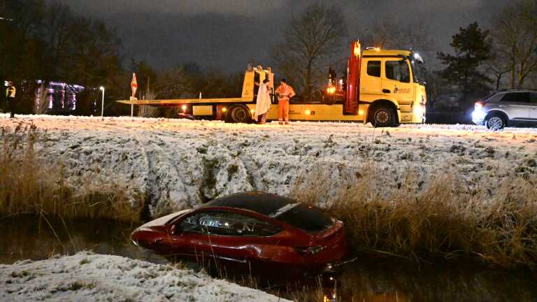 Auto te water langs Smaragdweg tijdens witte nacht