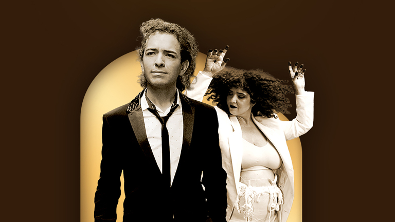 Twee personen in stijlvolle kleding, een man op de voorgrond en een vrouw met opgeheven handen op de achtergrond.