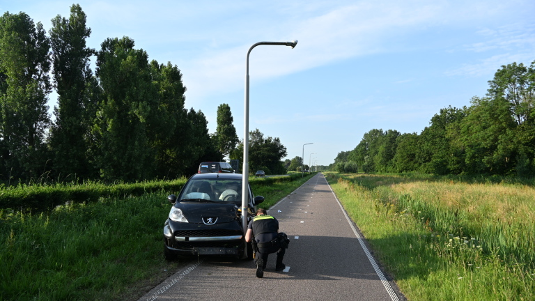Automobilist raakt van de weg op N203: lantaarnpaal komt deels onder auto terecht