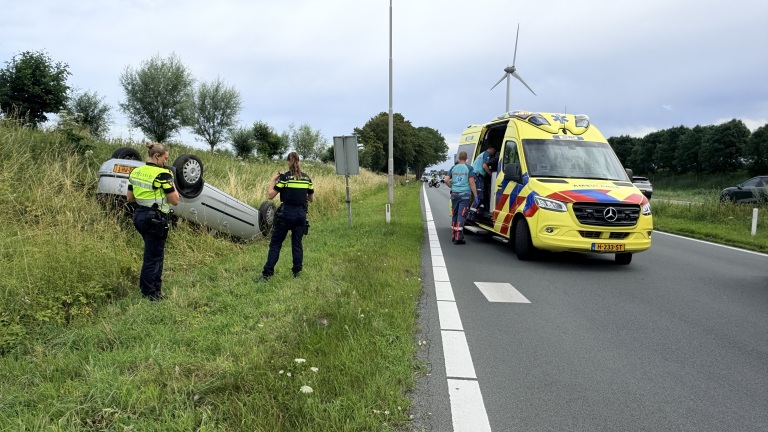 Bestuurder over de kop geslagen auto laat passagier aan lot over
