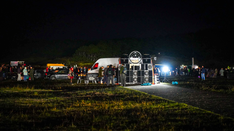 Honderden feestvierders dansen op versterkte muziek – in de duinen