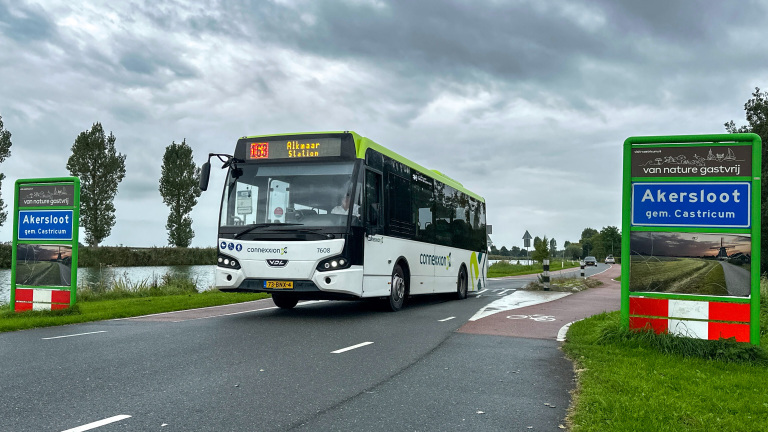 Connexxion-bus naar Alkmaar Station rijdt langs borden ‘Akersloot gem. Castricum’ op een landelijke weg