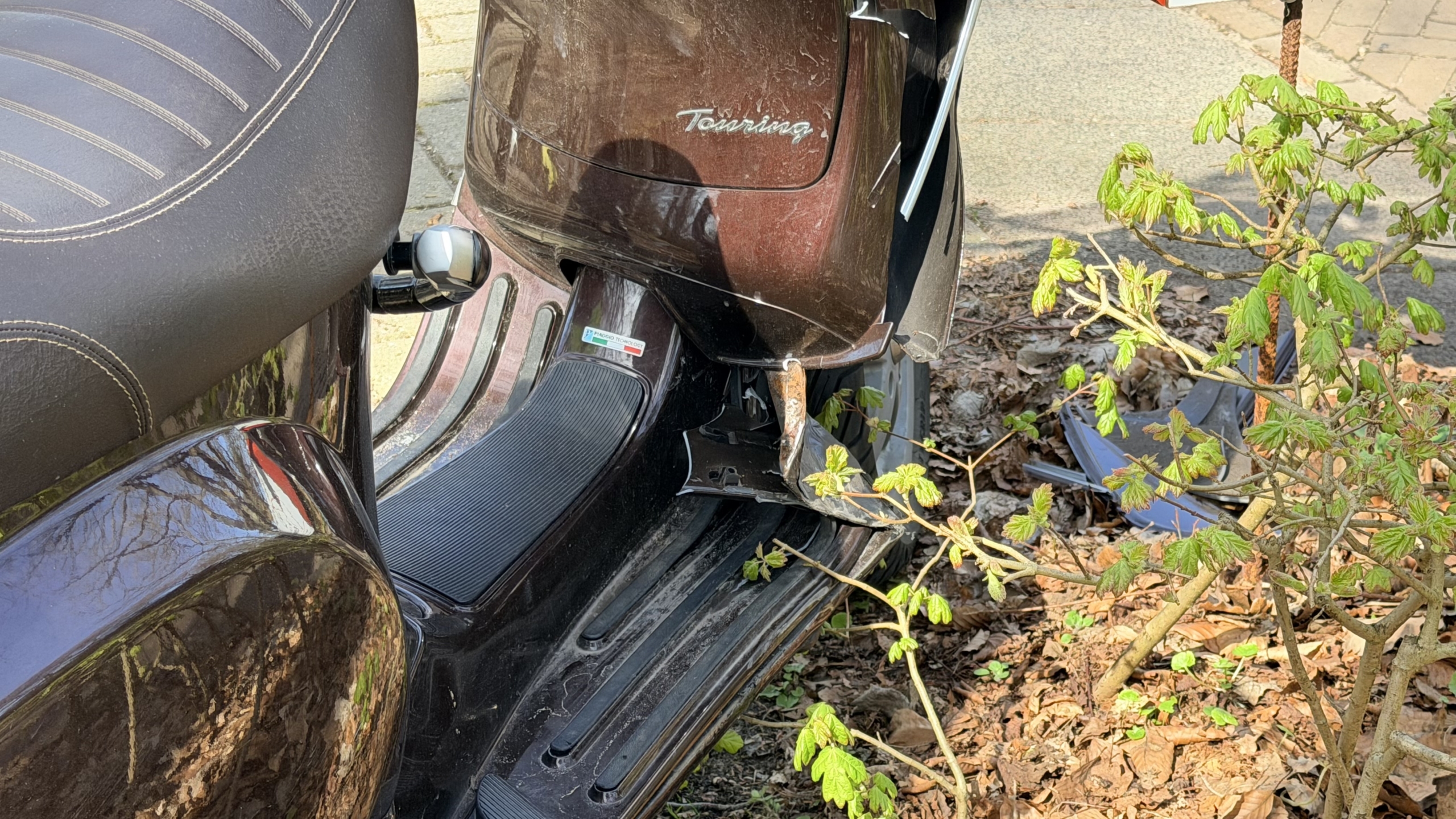 Een gele ambulance met blauwe en rode strepen staat op een weg; een verkeersbord geeft een zone van 30 km/u aan.