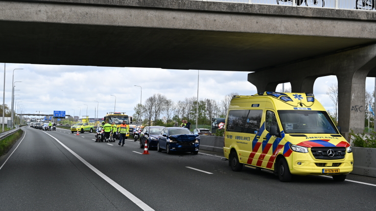 Politie en hulpdiensten bij een ongeval onder een brug in Heiloo, met toeschouwers bovenop de brug en een ambulance ter plaatse.