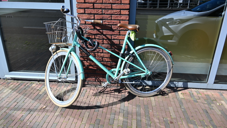 Een politie motorfiets en een ambulance staan op een plein; een medisch personeel in uniform staat dichtbij.