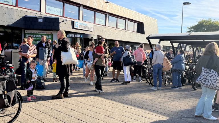 Drukte bij ingang van Sportcomplex Hoornse Vaart, met wachtende mensen, kinderen en fietsenrekken
