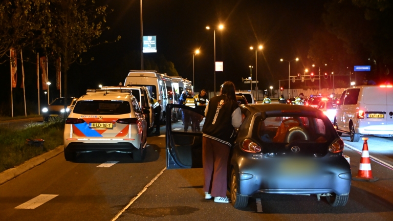 Politiecontrole ’s nachts op de weg, met agenten, verkeerskegels en auto’s die worden gecontroleerd