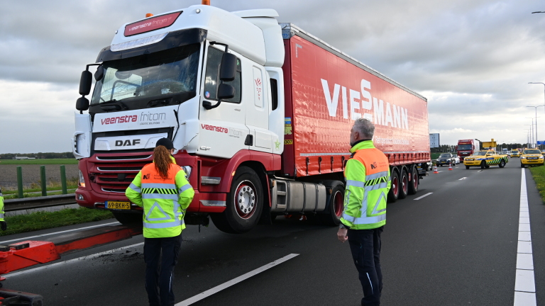 Gele weginspectievoertuigen met knipperlichten op drukke snelweg, met pijlwagen en afzetkegels in de verte