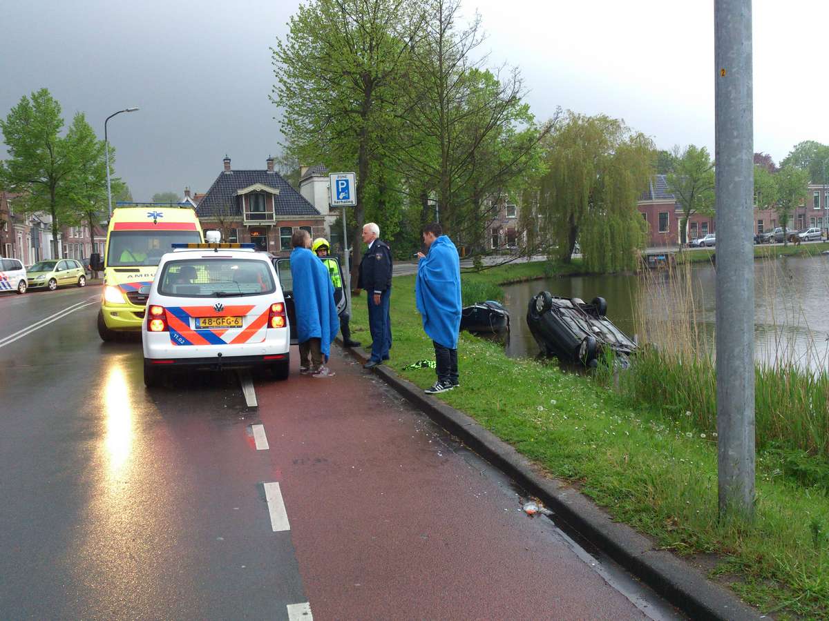 Auto op de kop de Geestersingel in: voorbijganger schiet te hulp (FOTO's)